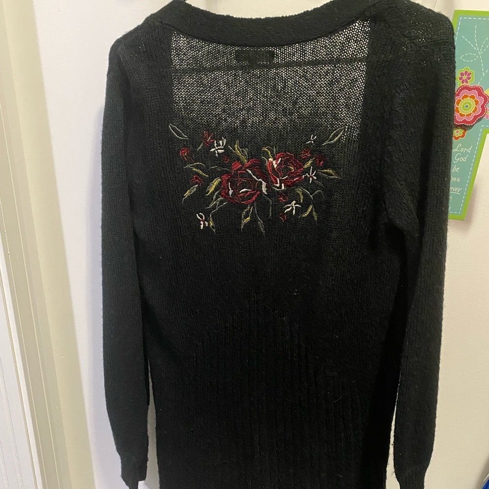 Black Mudd cardigan with flower embroidery on the back.